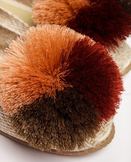Alpargatas planas de mujer Casa de Vera de color beige con adorno pompones