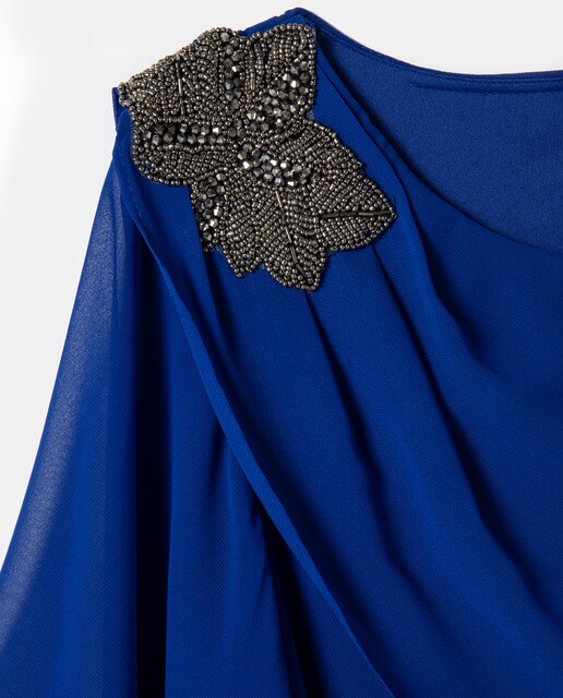 Vestido curto com camadas e pregadeira num ombro