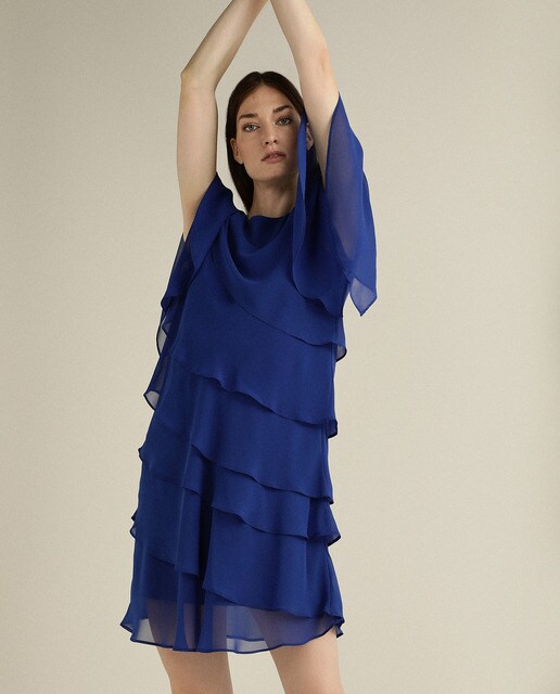Vestido curto com camadas e pregadeira num ombro