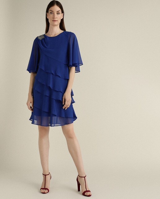 Vestido curto com camadas e pregadeira num ombro