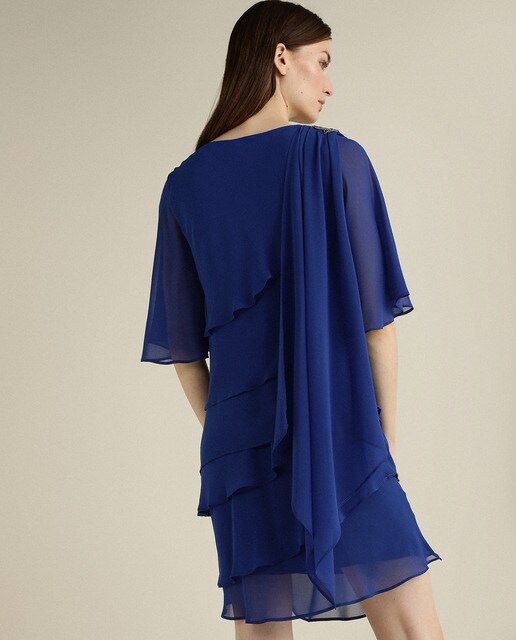 Vestido curto com camadas e pregadeira num ombro
