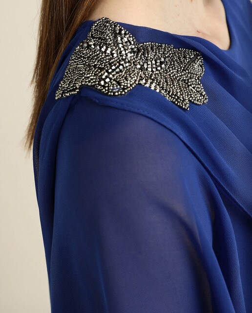 Vestido curto com camadas e pregadeira num ombro