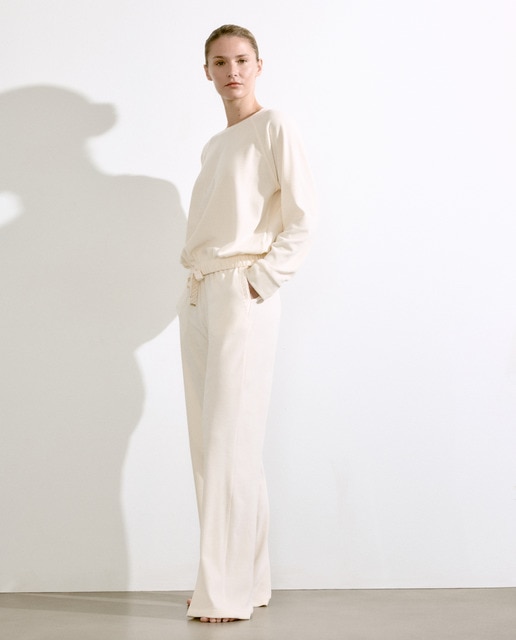 Imagem 0 de Calças em Veludo Suave com Perna Regular - Cru Bainha Elástica. Atacadores de Cetim com Monograma Brilhante. Placa Dourada.